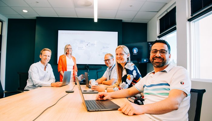 A group of Jotron employees sitting in a meeting room.