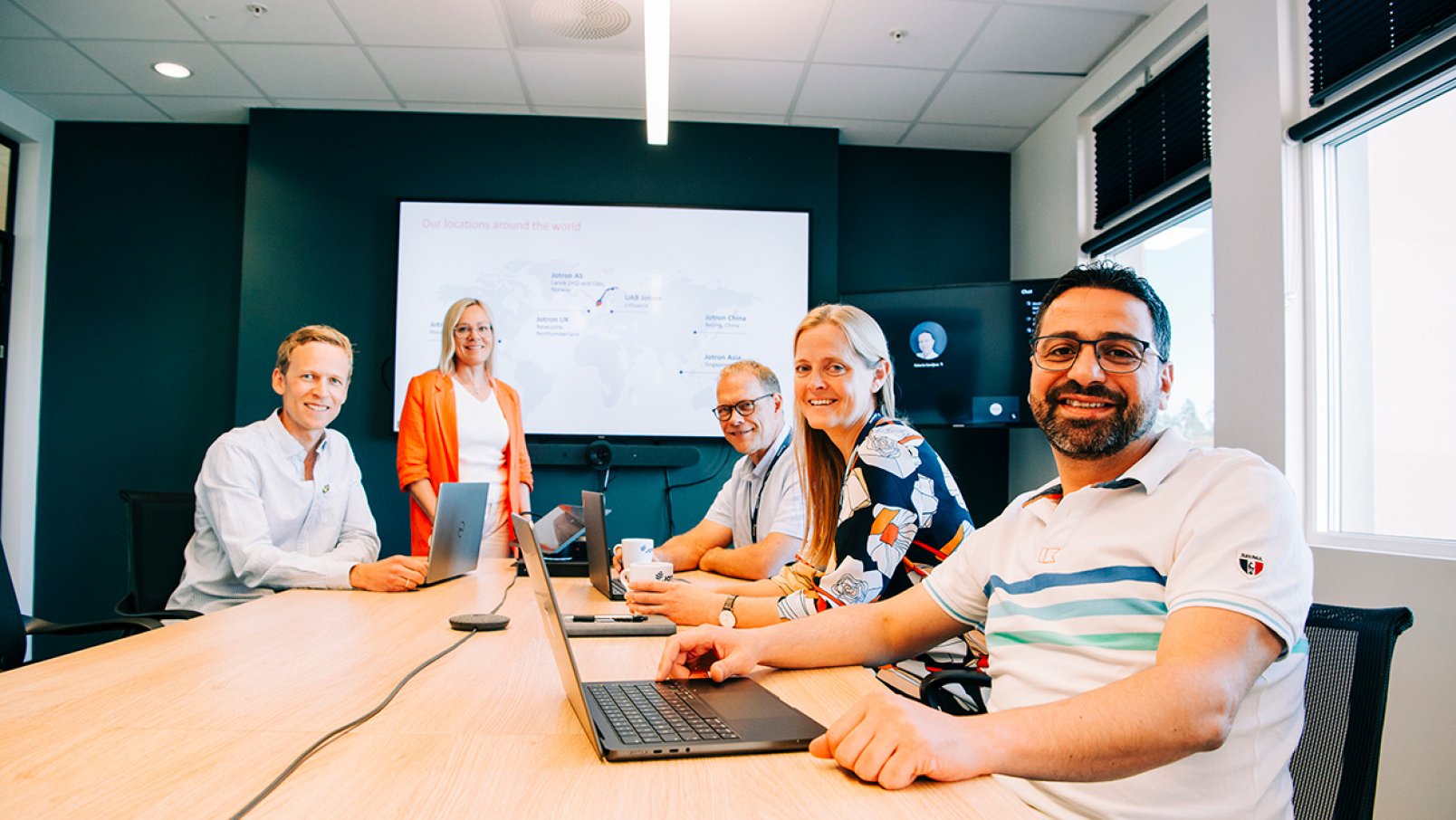 A group of Jotron employees sitting in a meeting room.
