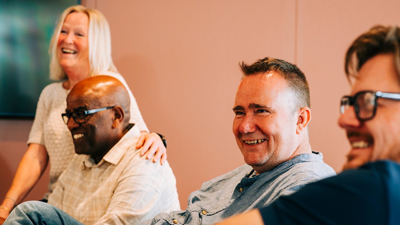 A group of smiling Jotron employees sitting in the launch area.