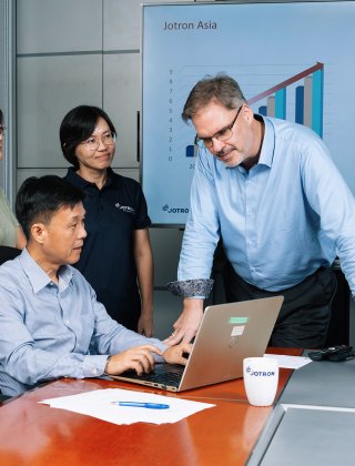 Jotron employees gathered in front of the PC. Jotron employees gathered in front of the PC.