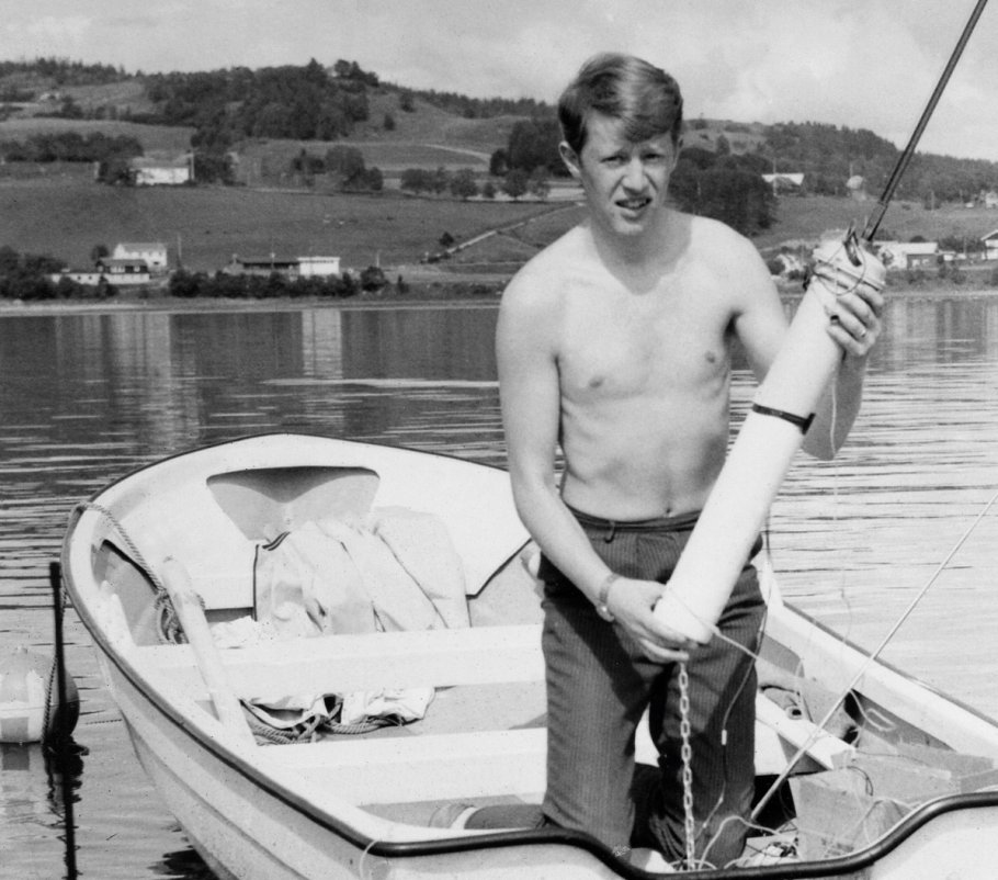 A young man in a small boat holding the the world first's EPIRB Tron 1 for testing.