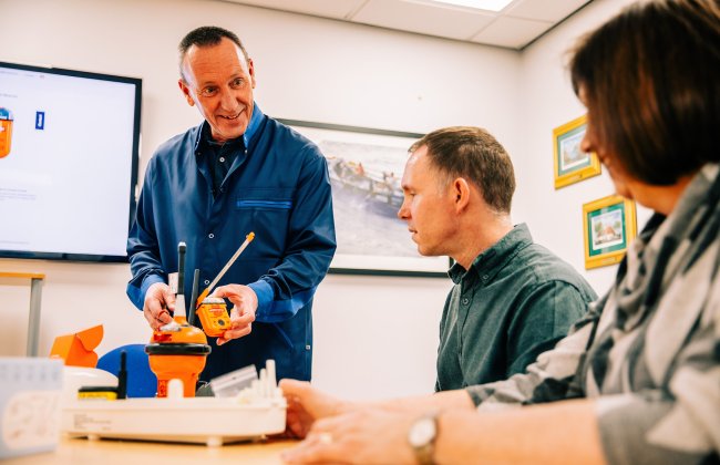 Jotron employee showing different EPIRBs. Jotron employee showing different EPIRBs.