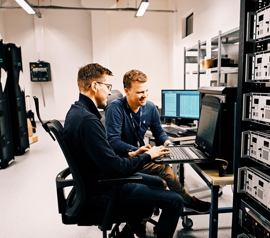 Two Jotron employees in front of a PC.