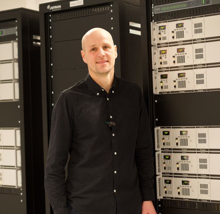 Jotron employee in front of a ATC radio rack.