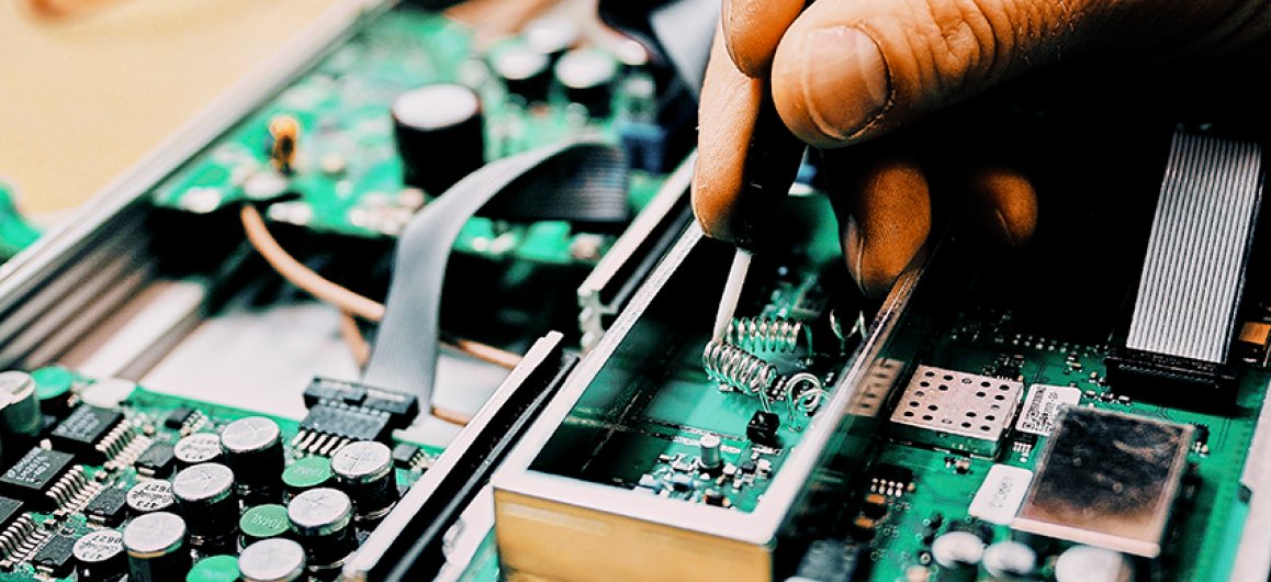 A hand soldering a circuit board.