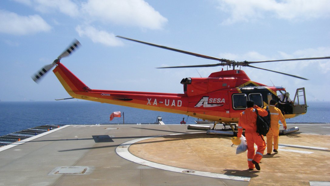 Workers boarding a helicopter to depart from an oil and gas platform.