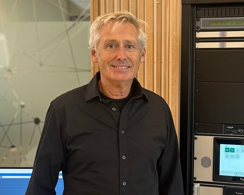 Jotron employee in front of a rack with ATC radios.