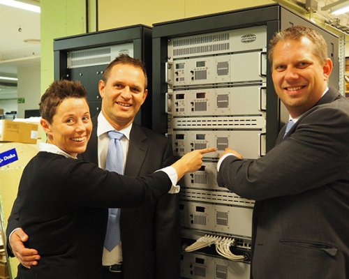 Jotron employees standing in front of a ATC radio rack.