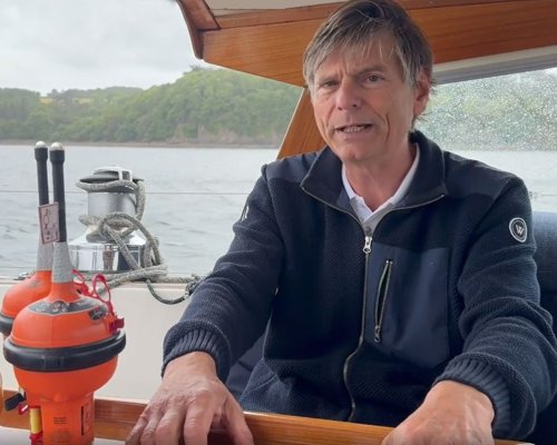 Jotron customer Leon is sitting in his sailboat, showcasing products in Jotron's GMDSS portfolio.