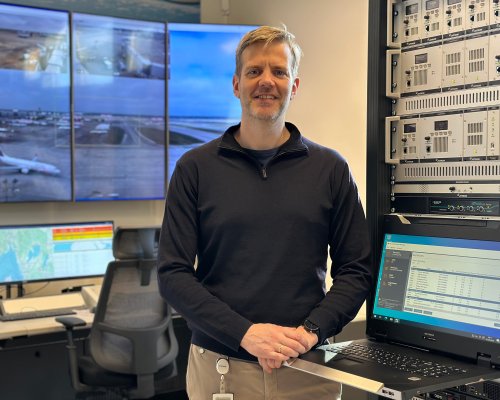 Jotron employee standing by an ATC radio rack.