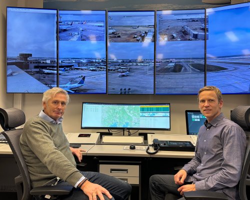 Two Jotron employees in front of air traffic control screens.
