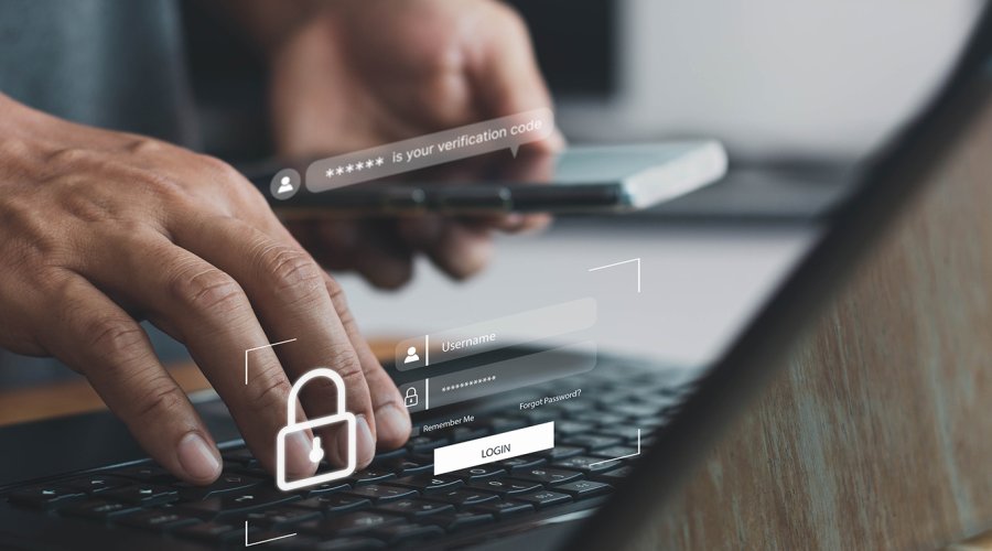 A photo illustrating cybersecurity, showing hands on a PC keyboard with login and security symbols displayed on the screen.