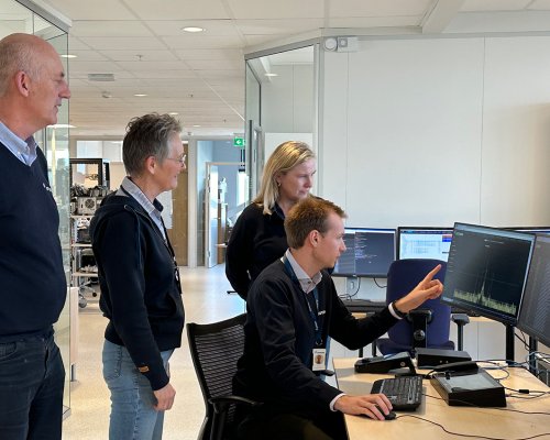 4 Jotron employees in front of a PC looking at the screen
