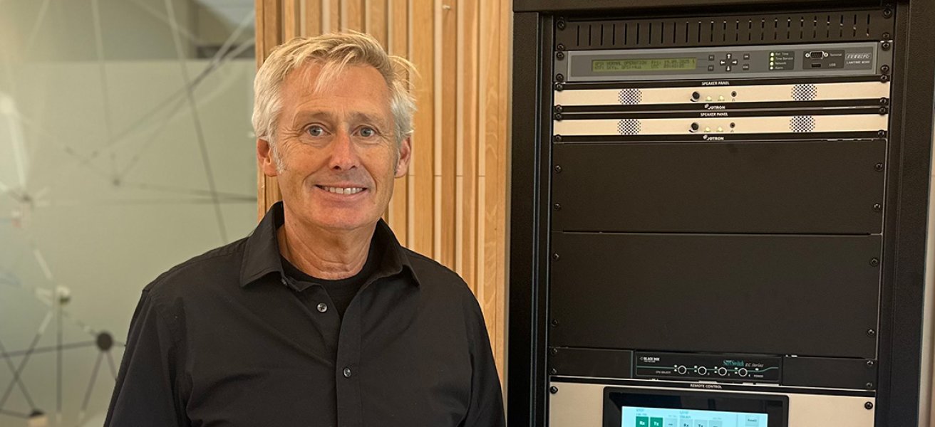 Jotron employee in front of a rack with ATC radios.