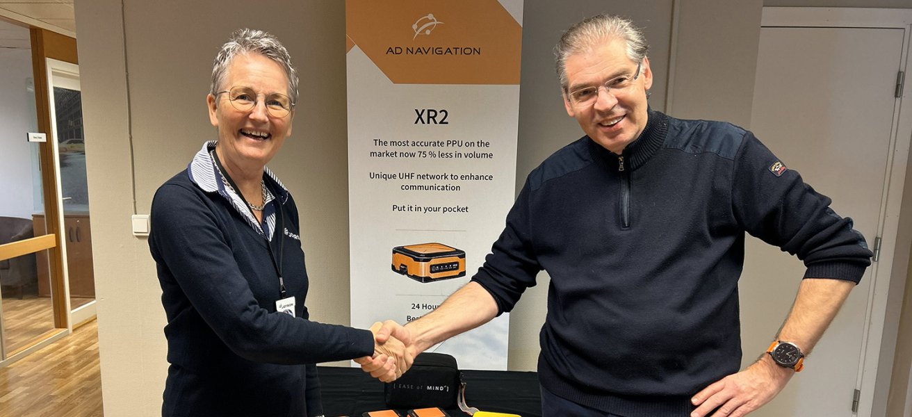 Merete Berdal, Jotron and Lorentz Ryan, AD Navigation shaking hands.