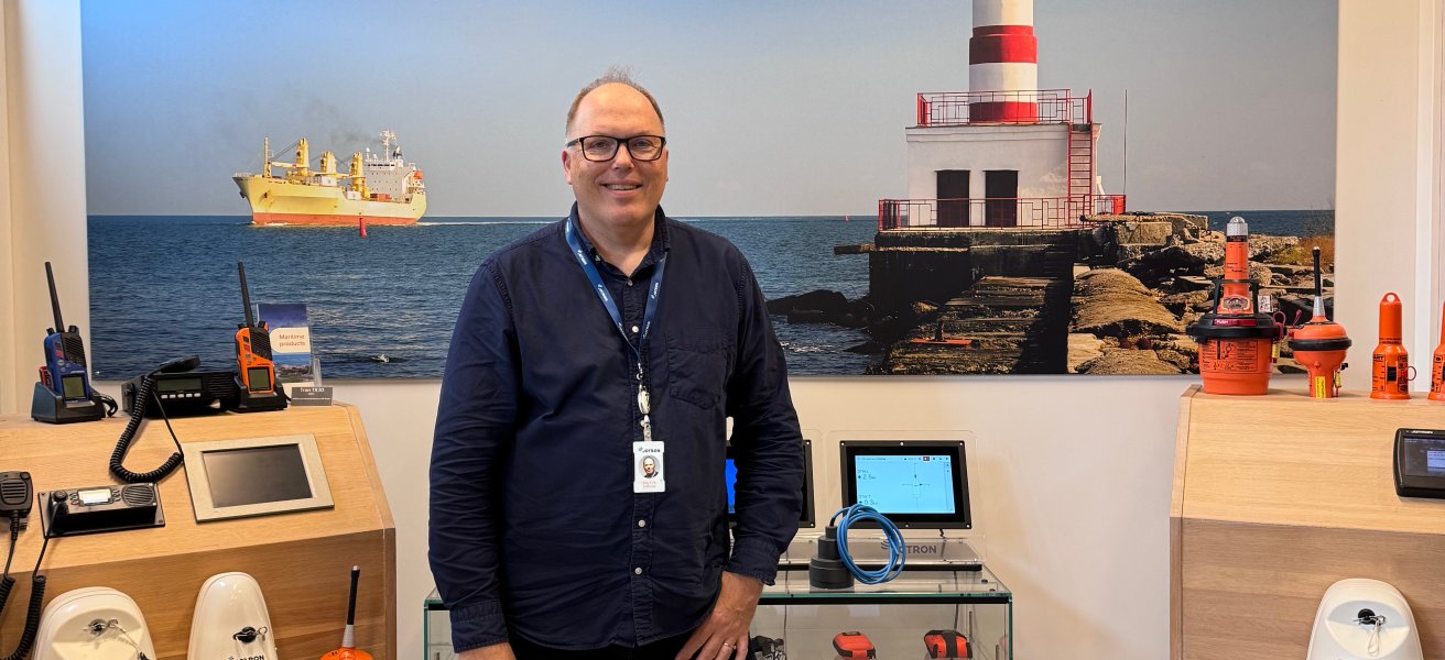Jotron's Maritime Director in front of racks with the company's maritime products.