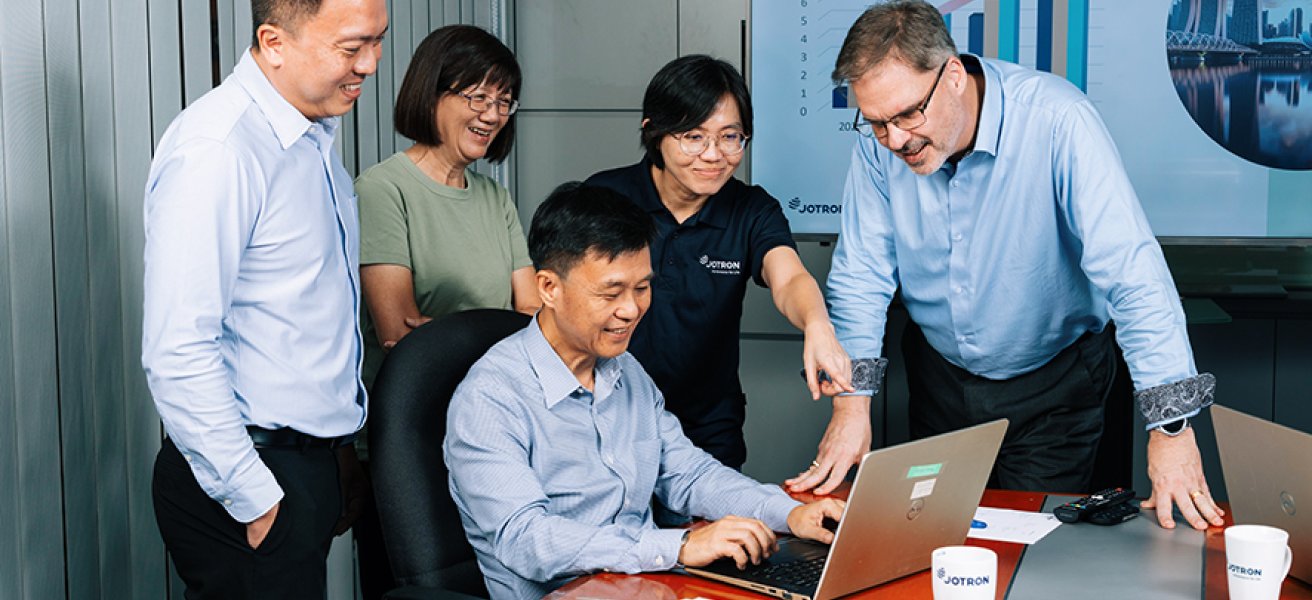 Jotron employees in front of the PC.