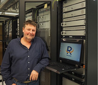 Jotron employee Oivind Ramde standing in front of a Ricochet Recorder rack.