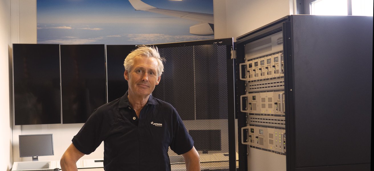 Christian Pindsle, International Sales Director for ATC & Coastal, Jotron in front of a ATC radio rack.