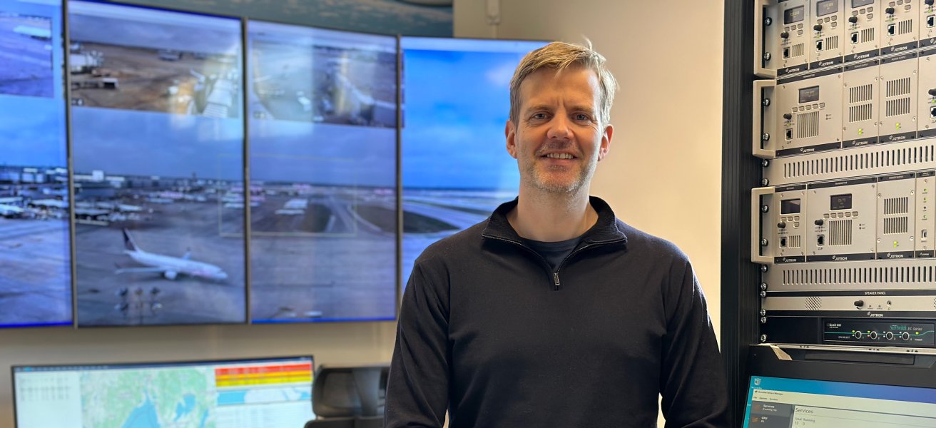 Jotron employee standing by an ATC radio rack.